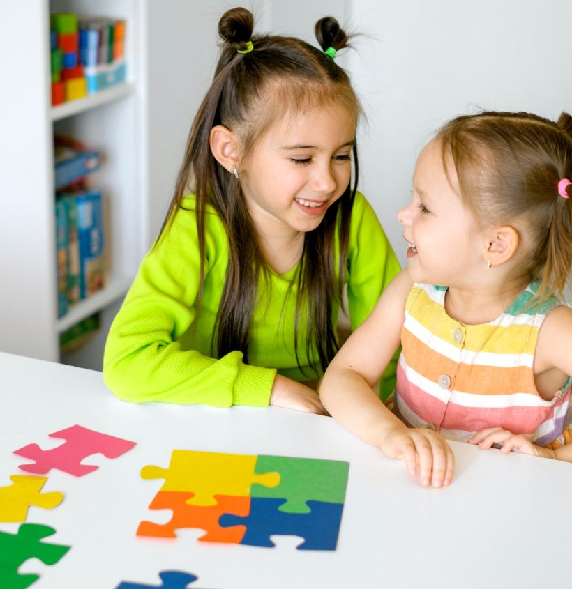 Children collect puzzles together at the desk in the children's room.