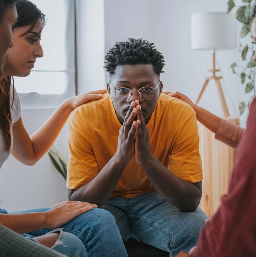 Sad African American guy get psychological support of counselor therapist